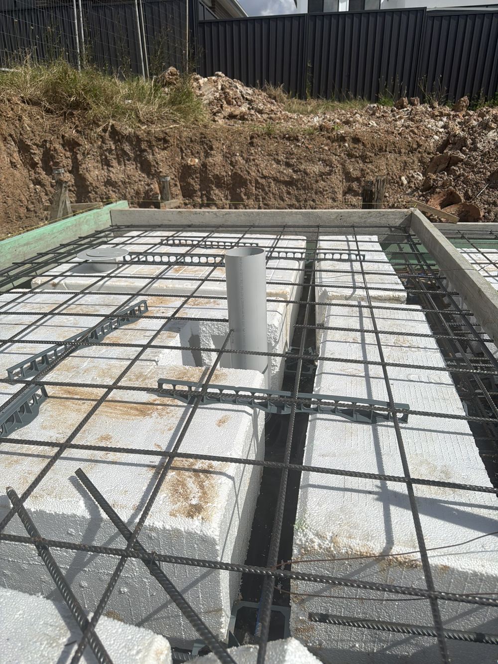 Drainage pipe left open before the pour, inviting debris and a blockage, found during a slab inspection in Tallawong